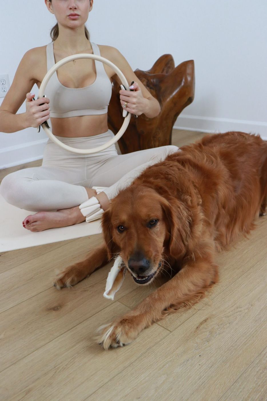a woman doing pilates while her golden retriever chews a single-ingredient navan chew